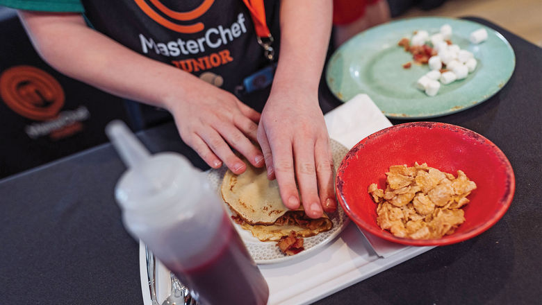 A young guest participates in a MasterChef Junior-inspired “Mystery Box Challenge” experience at a Dreams resort.