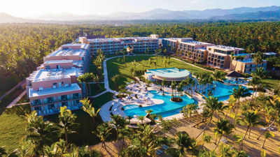 The rooms at Viva Miches by Wyndham are arranged in a horseshoe around a large lawn, facing the pool complex and beach.