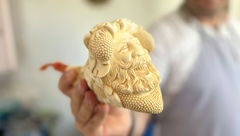 Sinan Onalci holding a meerschaum pipe with the face of the Greek god Dionysus.