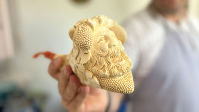 Sinan Onalci holding a meerschaum pipe with the face of the Greek god Dionysus.