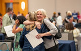 Cathy Kusuma Bennis of Audley Travel and Jennifer Hand of Champagne Vacations embrace after their 6-minute appointment.