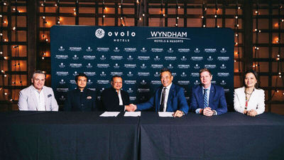 Girish Jhunjhnuwala, CEO of Ovolo Group, and Joon Aun Ooi, president of Asia Pacific for Wyndham Hotels & Resorts, shake hands to celebrate the signing of a partnership between Wyndham and Ovolo.
