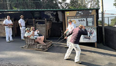 Visitors prepare for a wild ride down Funchal streets in the comfort of a wicker toboggan.