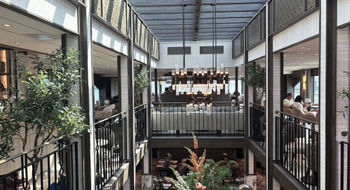 The ship's dining room, from which guests can see the wraparound lounge located a deck above, thanks to a split-level design.