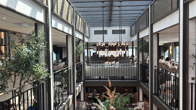 The ship's dining room, from which guests can see the wraparound lounge located a deck above, thanks to a split-level design.