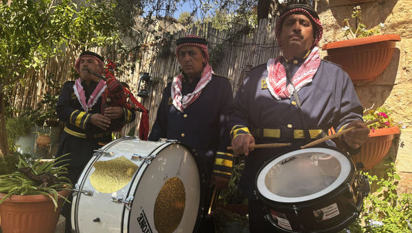 Three men serenade G Adventures travelers with drums and gerbeh, a Jordanian bagpipe, at Beit Khayrat Souf in Souf, Jordan.
