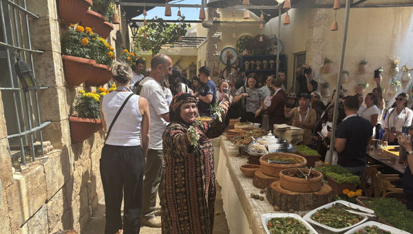 G Adventures travelers line up to eat at the buffet at Beit Khayrat Souf in Souf, Jordan.