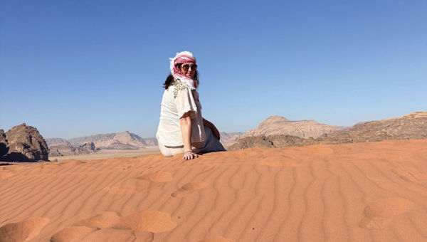 Tours editor Brinley Hineman sits on a sand dune in Wadi Rum