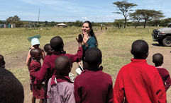 Sandra Solis, Abercrombie & Kent Philanthropy’s (AKP) coordinator in Peru, high-fives students in Kenya’s Masai Mara.