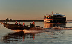 A skiff excursion with the Pure Amazon in the background. The Pure Amazon is Abercrombie & Kent's first South American riverboat.