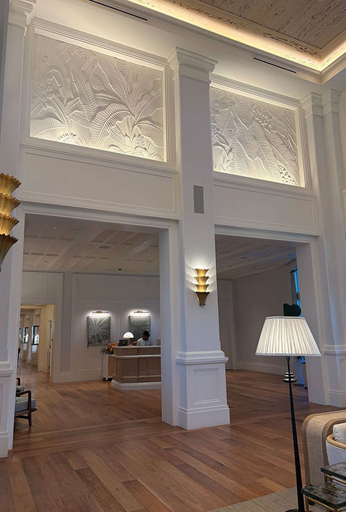 The two-story lobby of the Naples Beach Club, a Four Seasons Resort features stone panels of palm fronds and a bleached, pecky cypress ceiling. The two-story lobby of the Naples Beach Club, a Four Seasons Resort features stone panels of palm fronds and a bleached, pecky cypress ceiling.