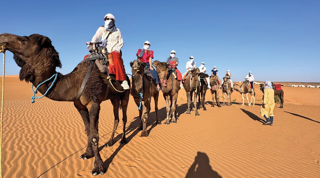 Travel Weekly's Brinley Hineman at the front of a caravan of camel riders.
