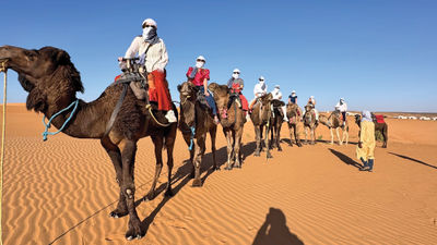 Travel Weekly's Brinley Hineman at the front of a caravan of camel riders.