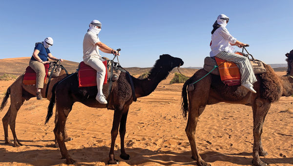 Abercromobie & Kent guests riding camels in the Sahara. Abercromobie & Kent guests riding camels in the Sahara.