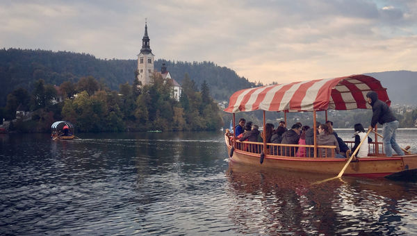 A historical church, accessible by colorful tourist boats, sits in the middle of Lake Bled. A historical church, accessible by colorful tourist boats, sits in the middle of Lake Bled.