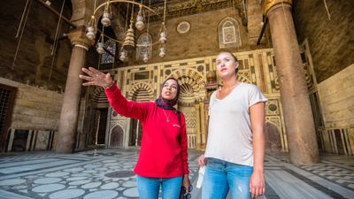 An Intrepid guide with a guest in a Cairo mosque. The tour company said it would resume tours in Egypt April 1.
