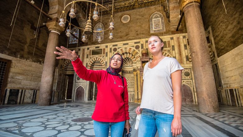 An Intrepid guide with a guest in a Cairo mosque. The tour company said it would resume tours in Egypt April 1.
