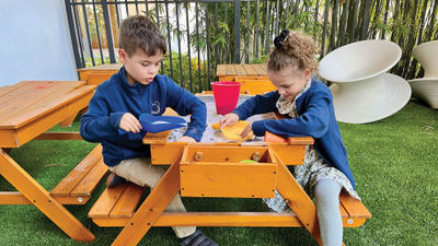 Two of the author's children hunt for buried treasure on the shaded patio at the Kids Club at Conrad Orlando.
