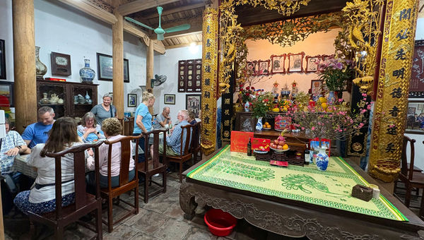 Dining in a family home in Northern Vietnam, with a magnificent gilded altar as the central feature.