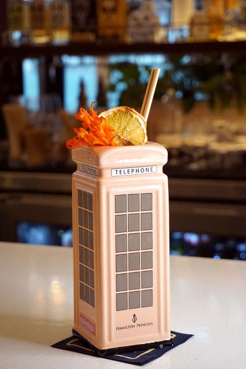 The Pink Phonebooth, a drink served at the Intrepid, comes in a replica of the property's patio landmark. It's a blend of vodka, guava, citrus, pineapple and sparkling wine. The Pink Phonebooth, a drink served at the Intrepid, comes in a replica of the property's patio landmark. It's a blend of vodka, guava, citrus, pineapple and sparkling wine.