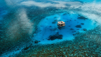 The Underwater Room at the Manta Resort is a three-level private suite with a submerged bedroom and a rooftop sundeck, anchored off the coast of Pemba Island in the Zanzibar Archipelago.