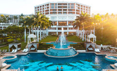 The adults-only Hibiscus Serenity Pool and fountains in front of the central tower of the resort.