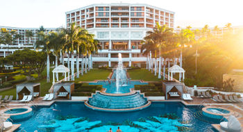 The adults-only Hibiscus Serenity Pool and fountains in front of the central tower of the resort.