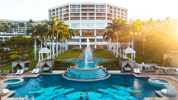 The adults-only Hibiscus Serenity Pool and fountains in front of the central tower of the resort.