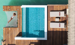 A guest relaxes at a Royalton Chic Antigua Overwater Suite.