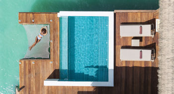 A guest relaxes at a Royalton Chic Antigua Overwater Suite.