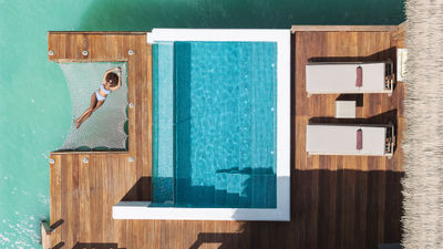 A guest relaxes at a Royalton Chic Antigua Overwater Suite.