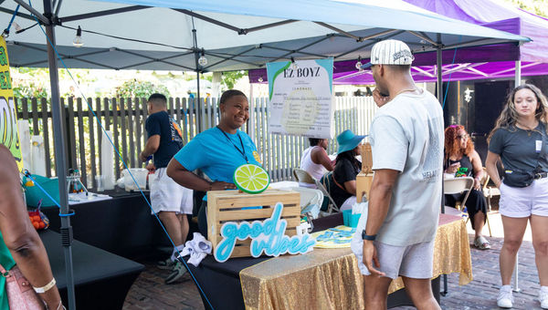 A vendor at EZ Boyz Lemonade serves customers at the festival's outdoor market.