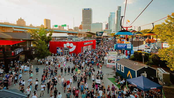 Thousands pack the grounds of Summerfest as a sky glider carries festival-goers above the crowd.