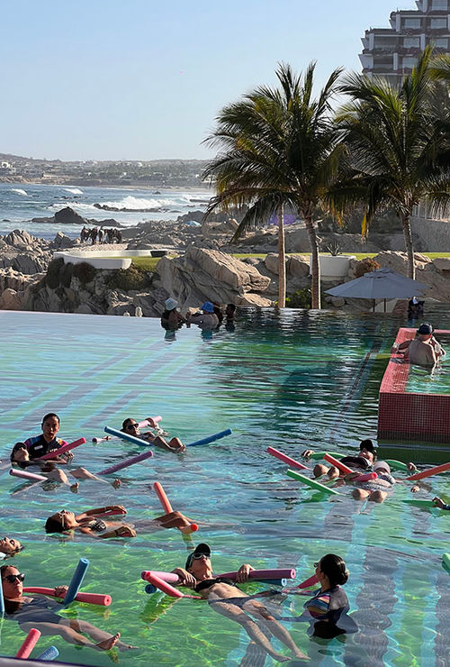 A group of guests enjoy a floating sound bath at the property's infinity pool.