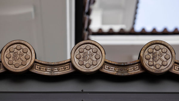 Roof tiles on the eaves, featuring the character 歌 or "to sing," remind visitors of the building’s original purpose. Roof tiles on the eaves, featuring the character 歌 or "to sing," remind visitors of the building’s original purpose.