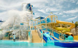 Splash Cay, the kids splash zone at Great Tides Waterpark, has multiple water slides and water sprays from overhead.