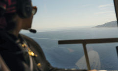 A guest looks out from a helicopter while on a Luxury Collection Expeditions experience.