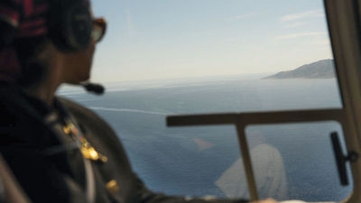 A guest looks out from a helicopter while on a Luxury Collection Expeditions experience.