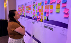 Travel advisor Kelsey Fox reads hand-written notes on Future Leaders in Travel's Intention Wall.