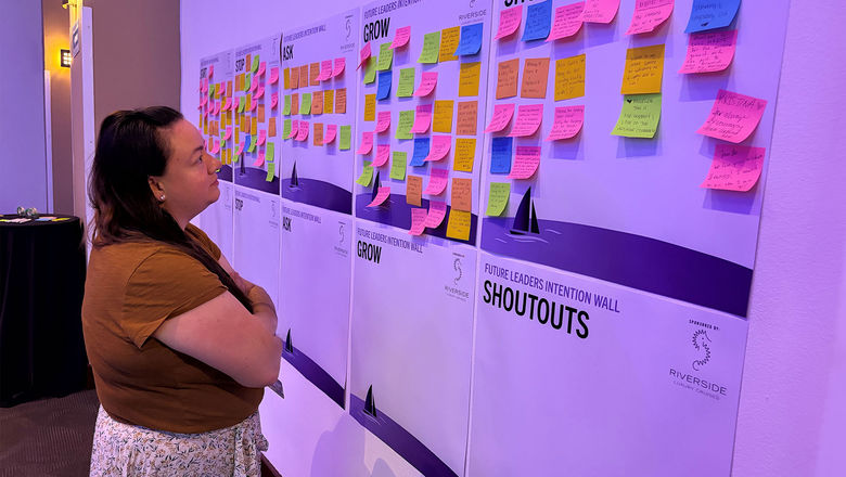 Travel advisor Kelsey Fox reads hand-written notes on Future Leaders in Travel's Intention Wall.