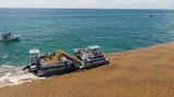A boat collecting sargassum in Mexico before it can reach the shoreline.