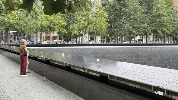 Twenty-five years after the 9/11 attacks, visitors arrive at the reflecting pools at the 9/11 Memorial & Museum that were built in the footprints of the twin towers.