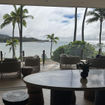 The Club at Ritz-Carlton Oahu Turtle Bay blends an indoor space with buffet-style food options and seating and an outdoor lanai with views to the resort's pools and the bay.