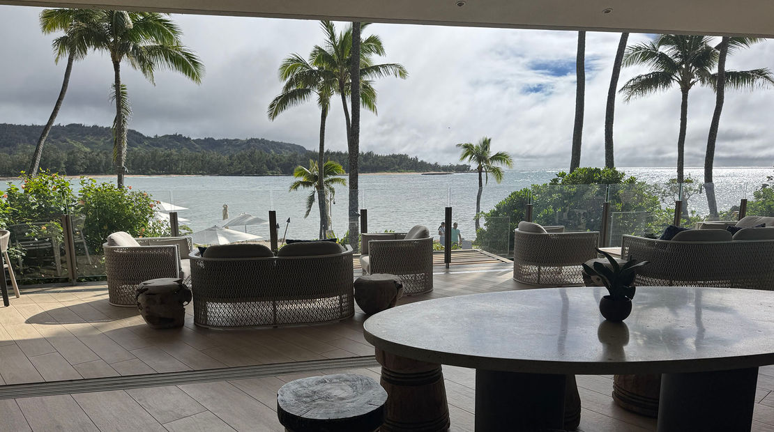 The Club at Ritz-Carlton Oahu Turtle Bay blends an indoor space with buffet-style food options and seating and an outdoor lanai with views to the resort's pools and the bay.