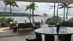 The Club at Ritz-Carlton Oahu Turtle Bay blends an indoor space with buffet-style food options and seating and an outdoor lanai with views to the resort's pools and the bay.