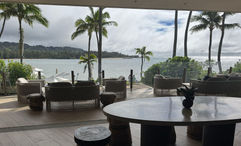 The Club at Ritz-Carlton Oahu Turtle Bay blends an indoor space with buffet-style food options and seating and an outdoor lanai with views to the resort's pools and the bay.