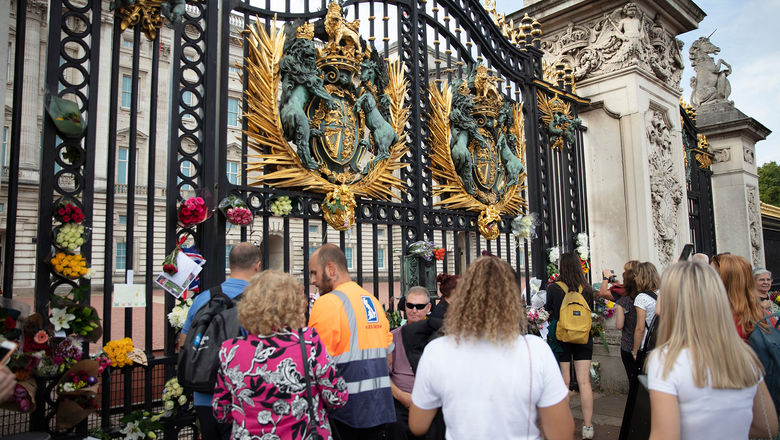 People visit Buckingham Palace to pay tribute to Queen Elizabeth II after her death.