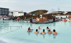 Summer tourists wading in the geothermal waters of the Blue Lagoon, one of the most popular attractions in Iceland.