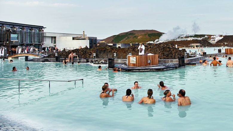 Summer tourists wading in the geothermal waters of the Blue Lagoon, one of the most popular attractions in Iceland.