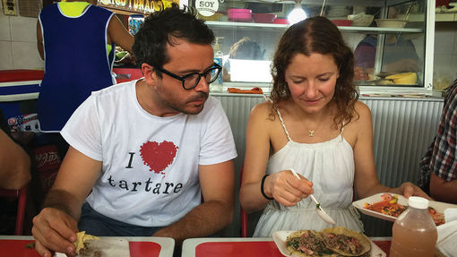 In the market of Izamal, Christian Puglisi, left, chef of Reloe in Copenhagen, listens to an explanation about the preparation of his breakfast from Elana Reygadas, of the restaurant Rosetta, in Mexico City.